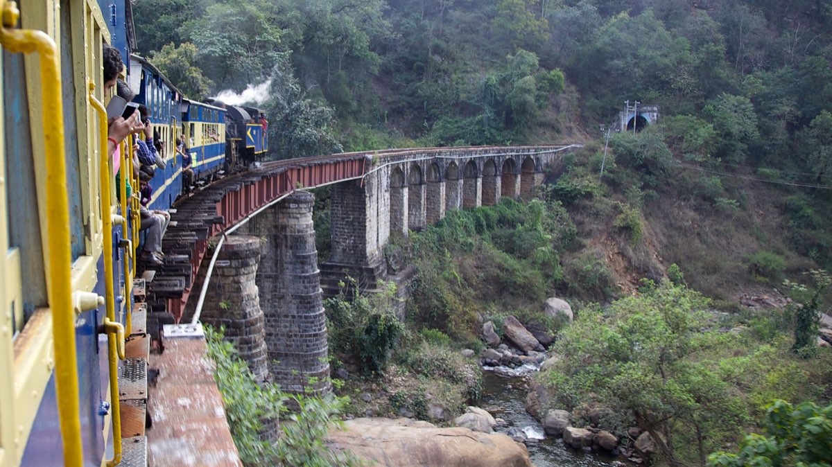 A Nilgiri Mountain Railway steam train crossing a bridge