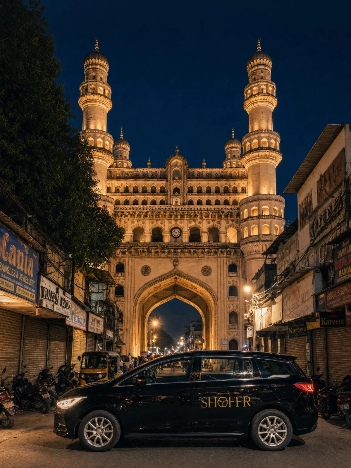 A Shoffr BYD e6 in front of the Charminar at night, Hyderabad